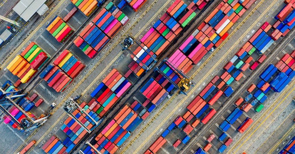 Aerial view of vibrant shipping containers at a busy Jakarta port, showcasing global trade.